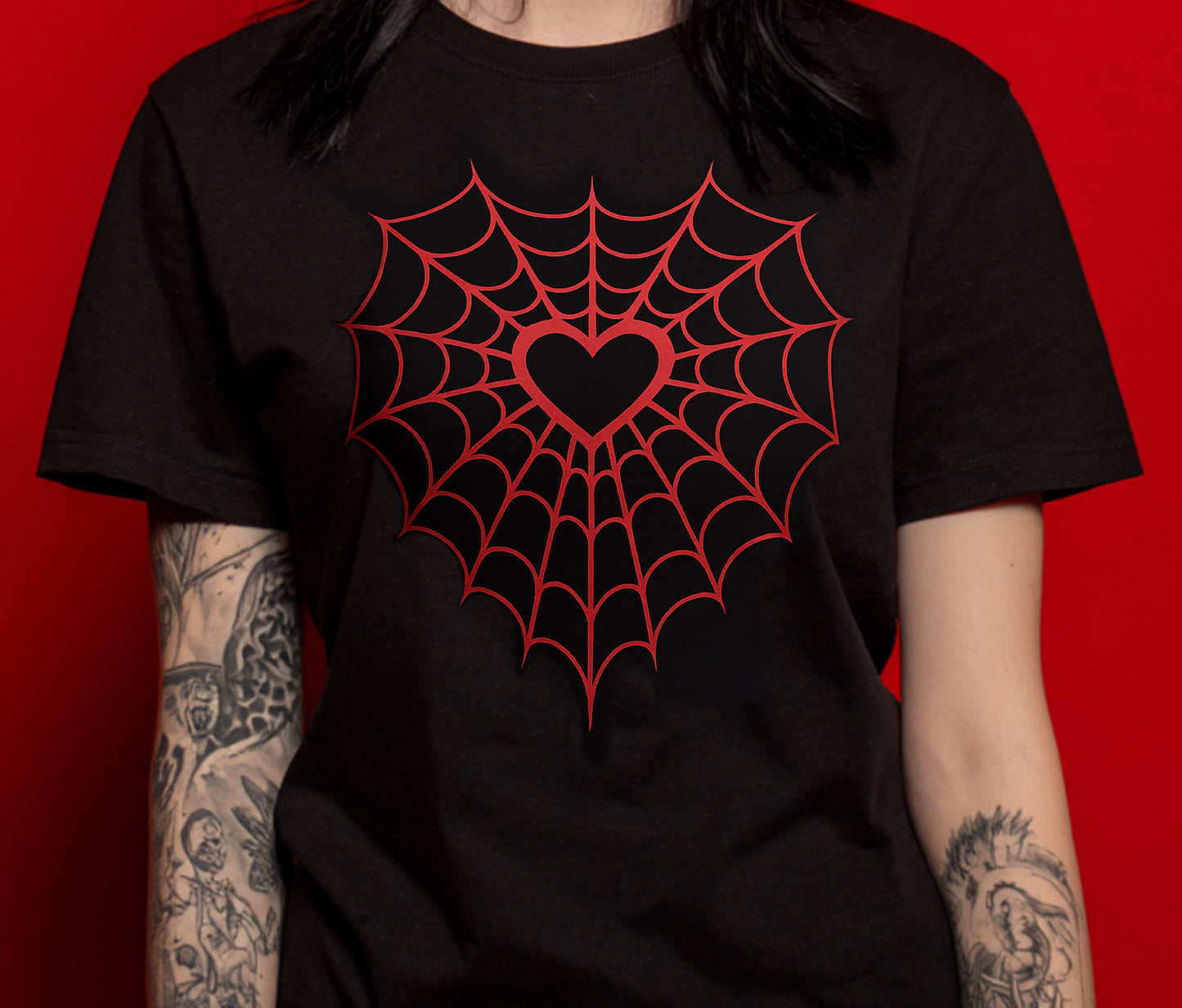Black t-shirt with red spider web and heart design on a red background