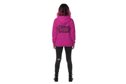 Person wearing a pink hoodie with text on the back, standing against a white background