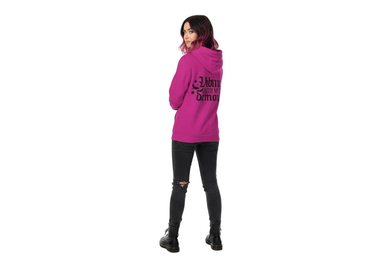 Person wearing a pink hoodie with text on it, standing against a white background