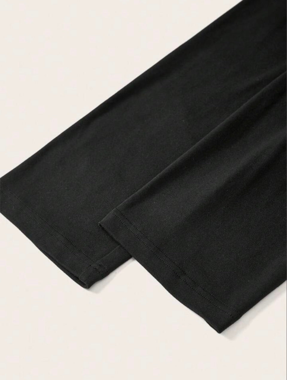 Off-shoulder black sweatshirt with white skull-and-tree design
