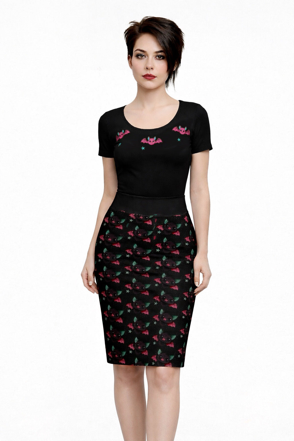 Woman wearing a black top with pink designs and a black skirt with red and green pattern on a white background