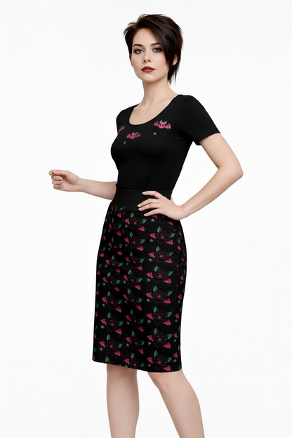 Woman wearing a black dress with colorful floral patterns on a white background