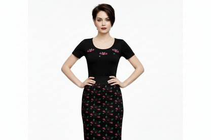 Woman wearing a black dress with pink floral patterns on a white background