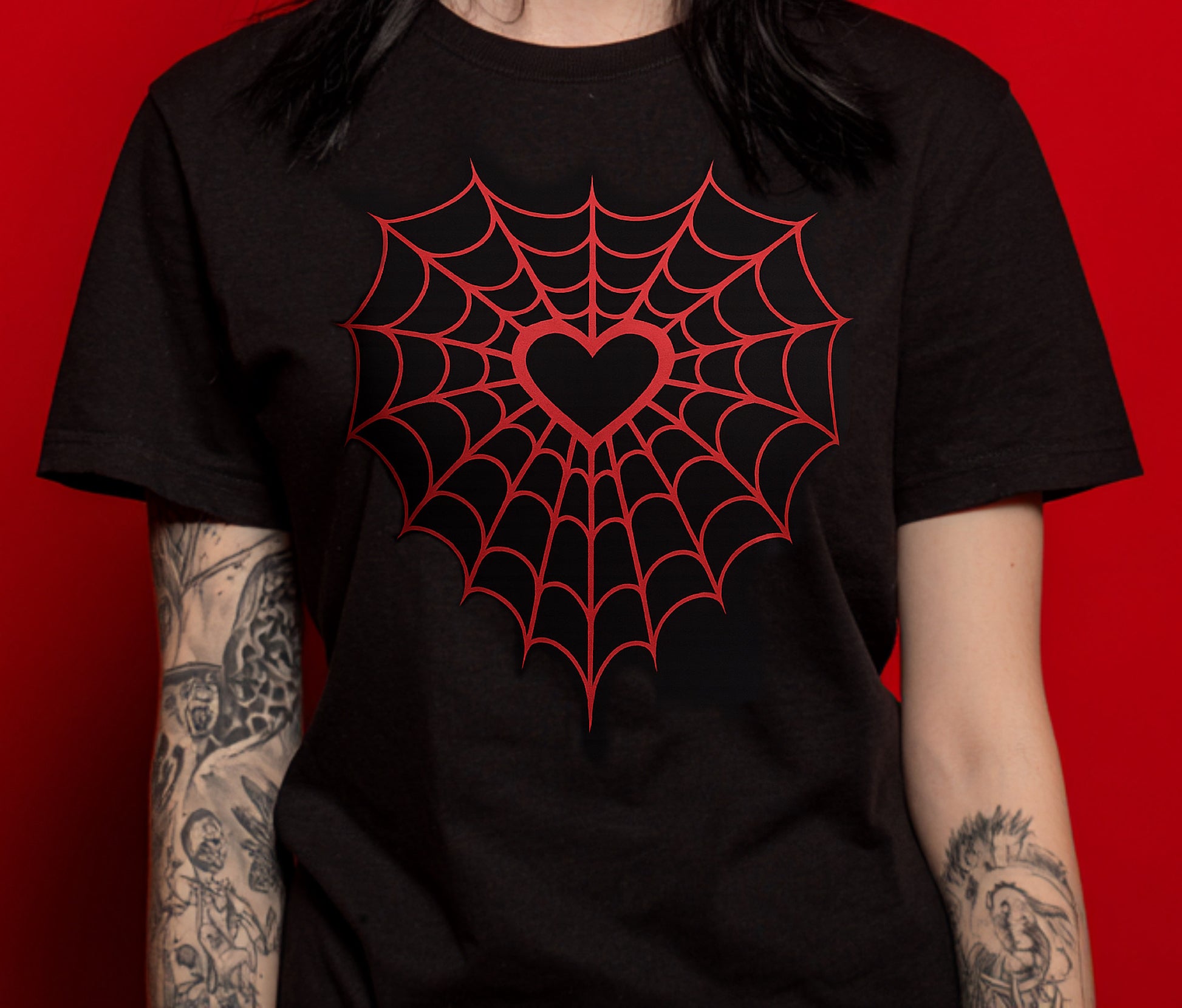 Black t-shirt with red spider web and heart design on a red background
