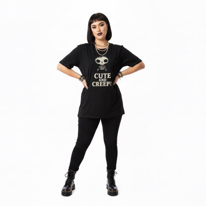 Person wearing a black t-shirt with 'Cute and Creepy' text and graphic, standing against a white background.