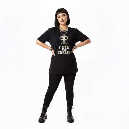 Person wearing a black t-shirt with 'Cute and Creepy' text and skull design on a white background