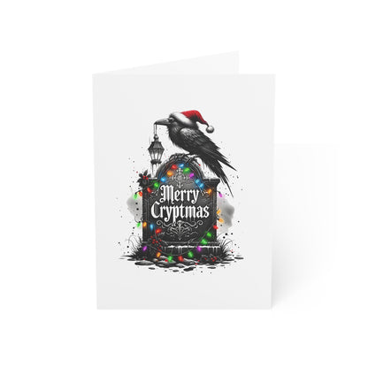 Card with a black crow wearing a Santa hat, perched on a gravestone with 'Merry Cryptmas' text, surrounded by Christmas lights on a white background.